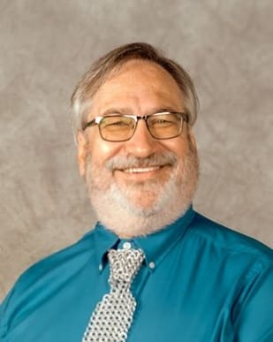 Photo of Steven H Silver wearing a green shirt, checkered tie and eyeglasses